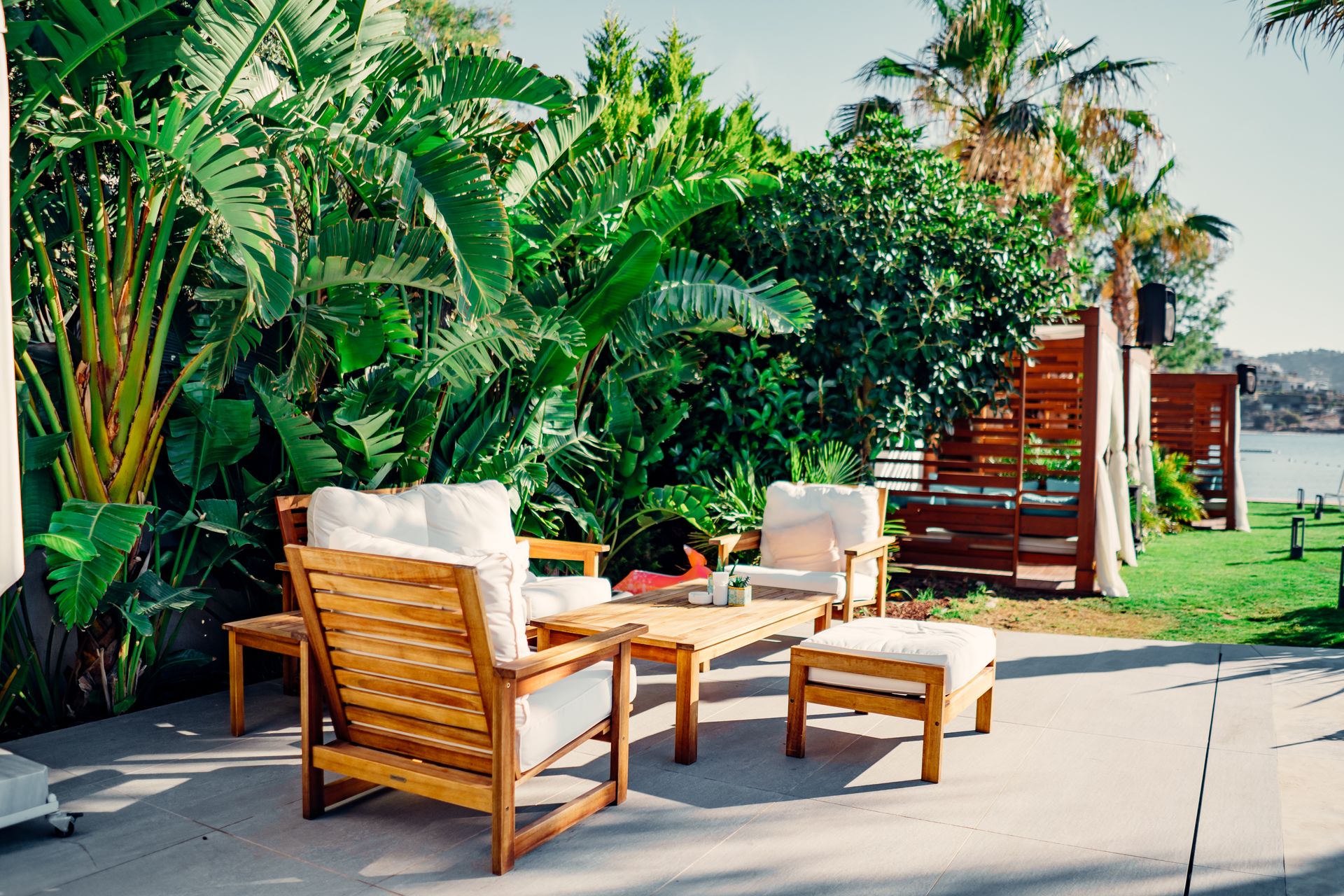 Outdoor patio with wooden furniture surrounded by greenery