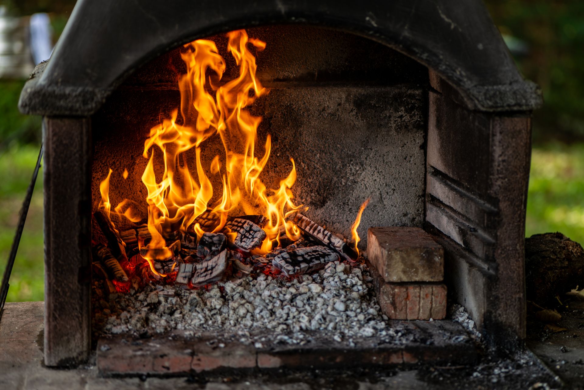 Outdoor fireplace with vibrant flames and burning logs